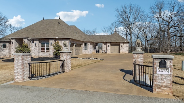 french country home featuring brick siding, an attached garage, concrete driveway, and roof with shingles