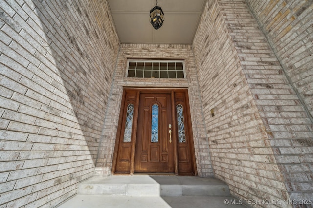 doorway to property with brick siding