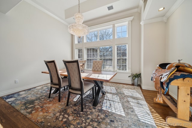 dining space featuring crown molding, baseboards, visible vents, and a chandelier