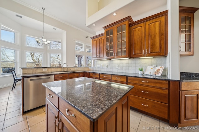 kitchen with tasteful backsplash, visible vents, a peninsula, stainless steel dishwasher, and a sink