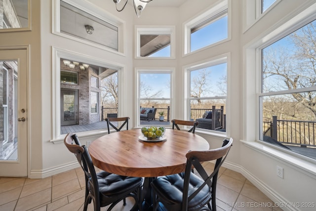 dining space featuring a notable chandelier, light tile patterned floors, and baseboards