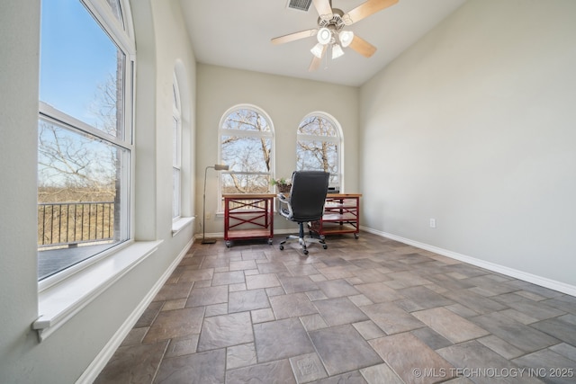 home office featuring a ceiling fan, stone finish floor, visible vents, and baseboards