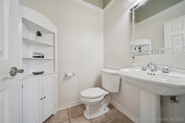 half bath with tile patterned floors, toilet, and baseboards