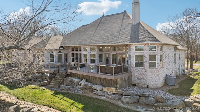 back of property featuring brick siding, a wooden deck, cooling unit, a chimney, and crawl space