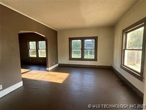 unfurnished room with baseboards and a wealth of natural light