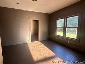 unfurnished room featuring dark wood-style flooring