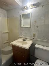 bathroom featuring a shower, toilet, and vanity