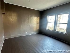 unfurnished room featuring baseboards and wood finished floors