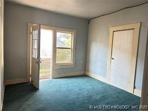 carpeted spare room featuring baseboards