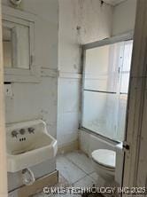 bathroom with toilet and tile patterned flooring