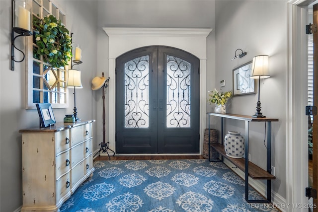 foyer featuring french doors, arched walkways, and a healthy amount of sunlight