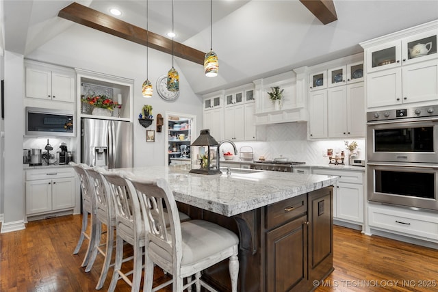 kitchen featuring a sink, lofted ceiling with beams, decorative backsplash, and stainless steel appliances