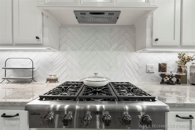 kitchen featuring tasteful backsplash, white cabinetry, and light stone countertops