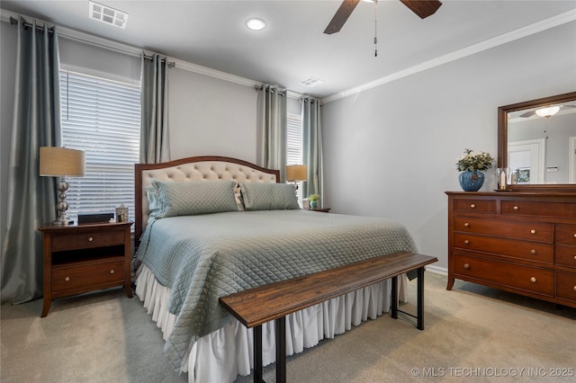 bedroom with a ceiling fan, crown molding, light colored carpet, and visible vents