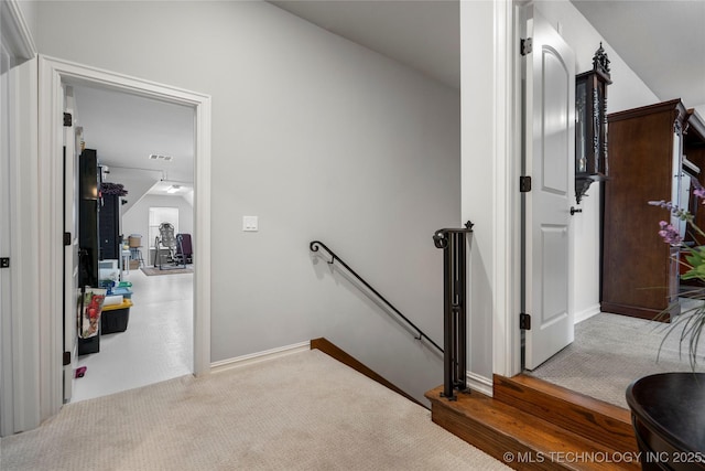 corridor featuring an upstairs landing, baseboards, and carpet