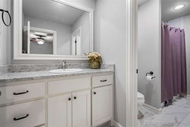 bathroom with baseboards, toilet, marble finish floor, and vanity