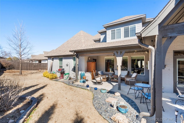 rear view of property with a patio, fence, brick siding, and a shingled roof