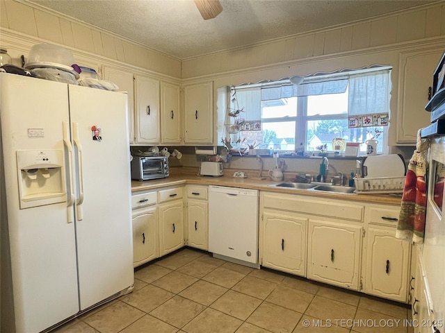 kitchen with ceiling fan, light tile patterned floors, white appliances, a textured ceiling, and a sink