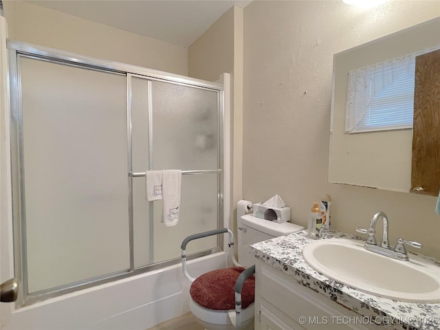 full bathroom featuring enclosed tub / shower combo, toilet, and vanity