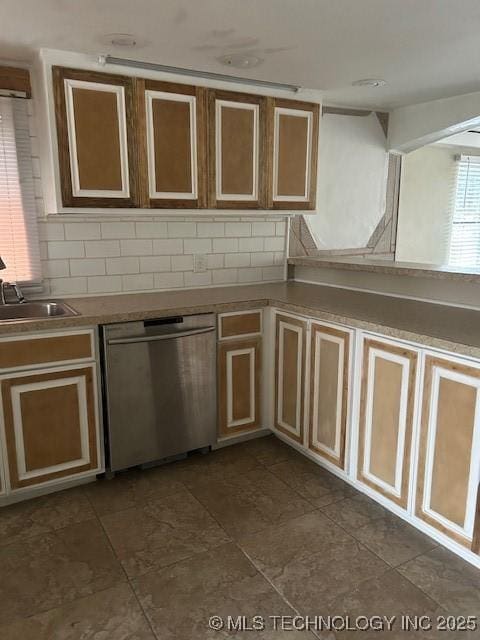 kitchen featuring dishwasher, tasteful backsplash, and a sink