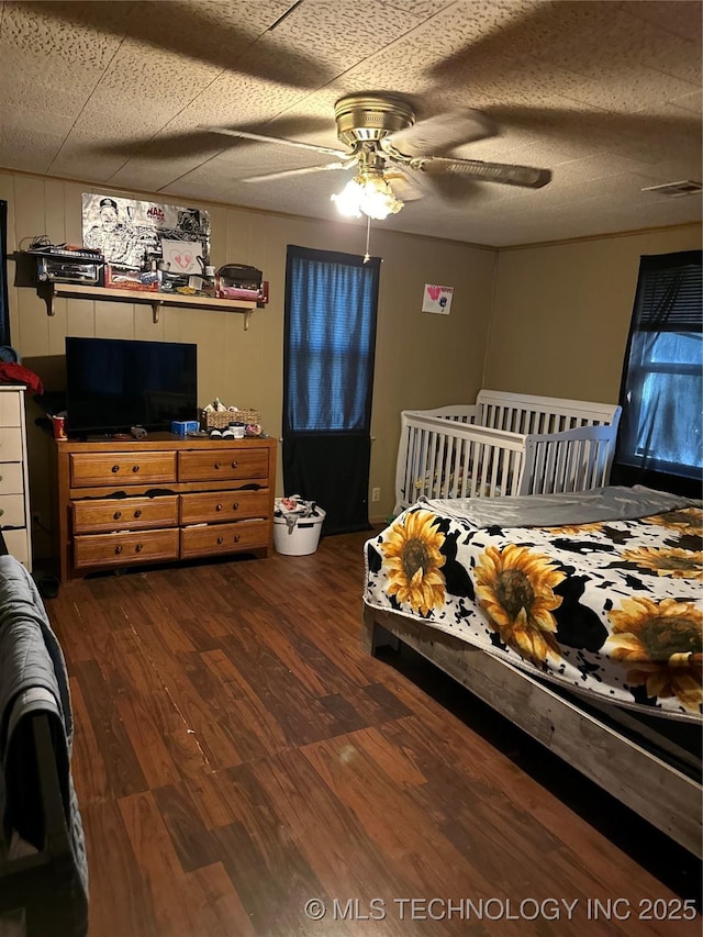 bedroom featuring wood finished floors, visible vents, and ceiling fan