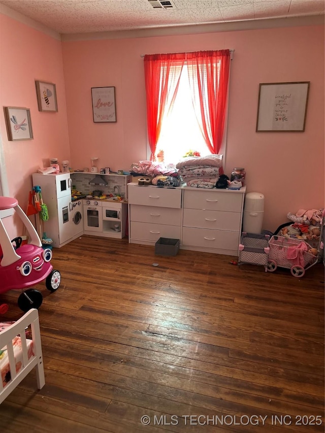 playroom featuring visible vents, a textured ceiling, and hardwood / wood-style floors