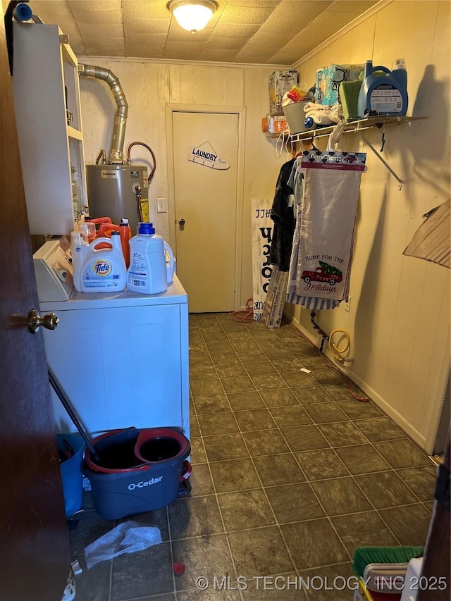 laundry area with gas water heater, wooden walls, washing machine and dryer, and laundry area