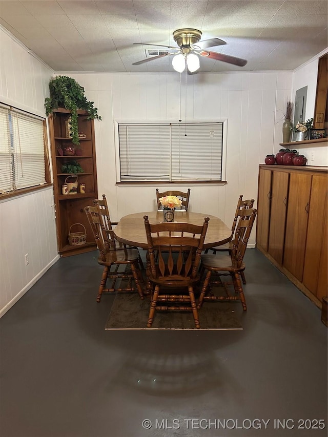 dining space featuring concrete flooring and a ceiling fan