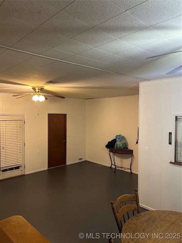 interior space featuring baseboards and a ceiling fan