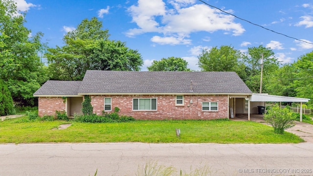 300 W 1st Ave, Bristow, OK 74010 - view of front of home with a carport, brick siding, a front yard, concrete driveway, and a shingled roof