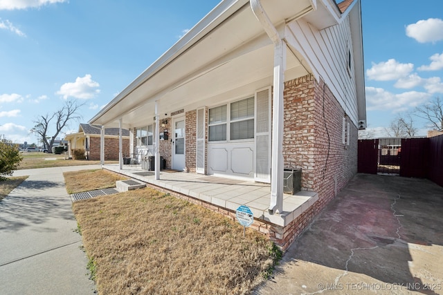 exterior space with brick siding and a porch