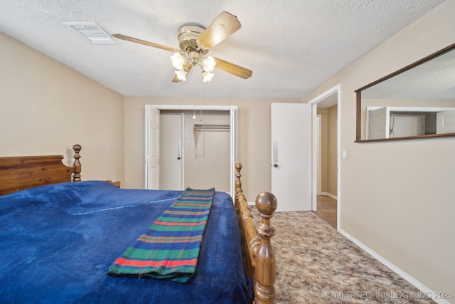 carpeted bedroom featuring baseboards, visible vents, ceiling fan, a closet, and a textured ceiling