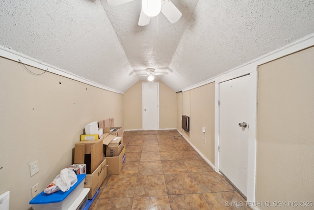 bonus room with a textured ceiling, ceiling fan, and vaulted ceiling