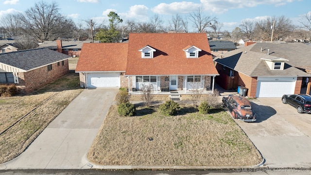 view of front of home featuring brick siding, a residential view, a porch, and driveway