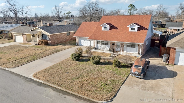 view of front of property featuring a garage, brick siding, covered porch, and concrete driveway