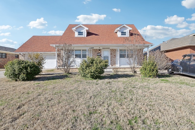 cape cod house with brick siding, a front lawn, and an attached garage