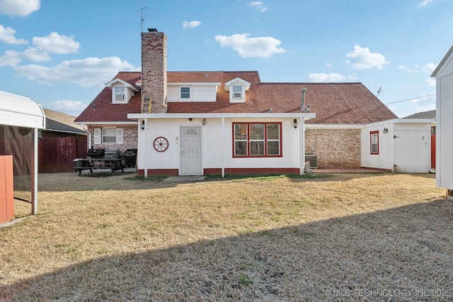 rear view of property with cooling unit, fence, a shingled roof, a chimney, and a lawn