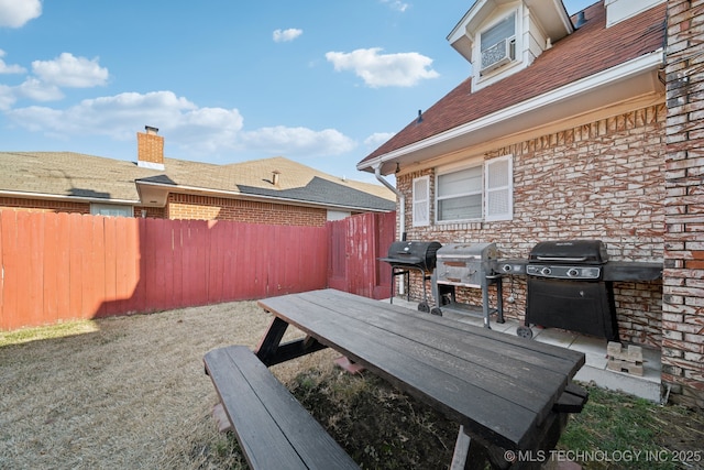 view of patio with area for grilling and a fenced backyard