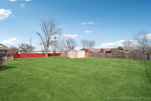 view of yard featuring an outbuilding, a storage unit, and a fenced backyard