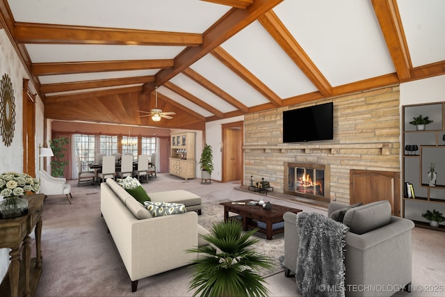 living area featuring lofted ceiling with beams, carpet floors, and a stone fireplace
