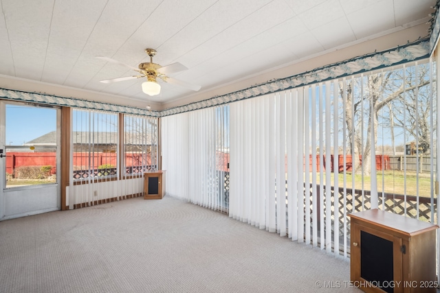 unfurnished sunroom with a ceiling fan