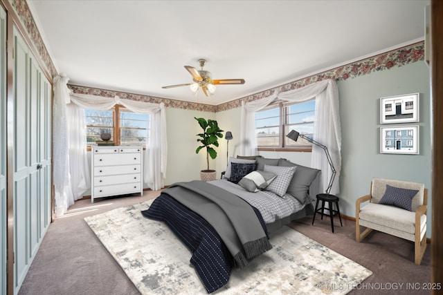 carpeted bedroom with a ceiling fan and baseboards