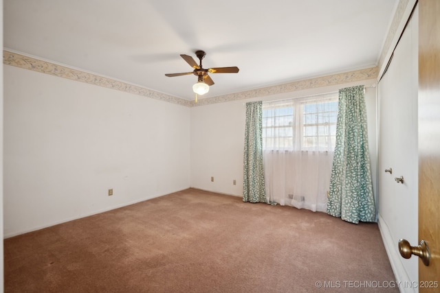 spare room with carpet flooring and a ceiling fan