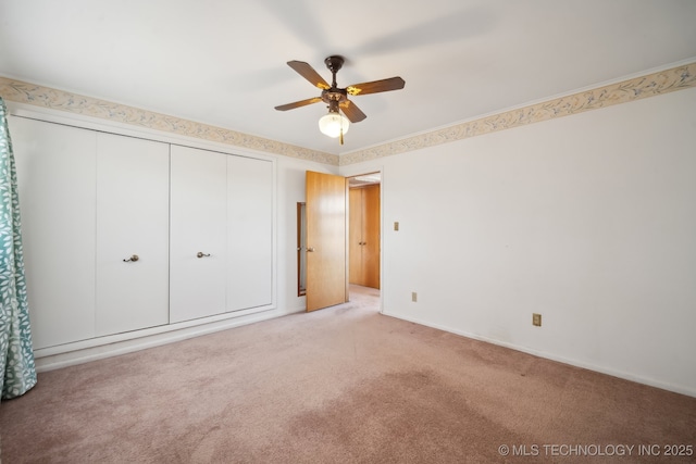 unfurnished bedroom featuring a closet, baseboards, carpet, and ceiling fan