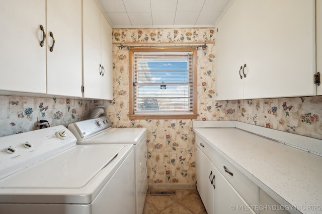 washroom featuring wallpapered walls, baseboards, ornamental molding, washer and dryer, and cabinet space