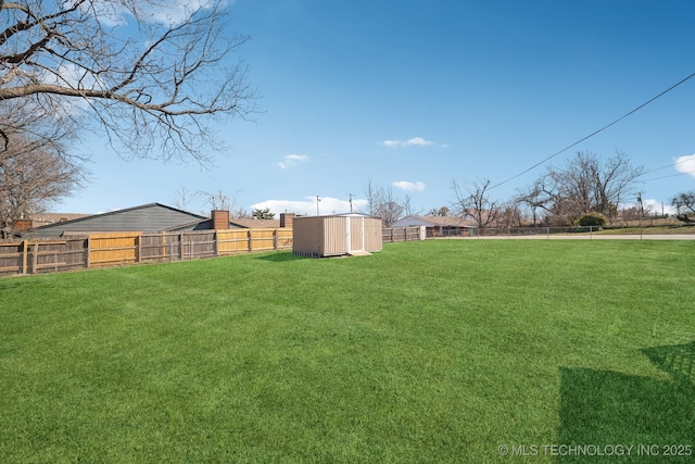 view of yard featuring an outbuilding, a shed, and a fenced backyard