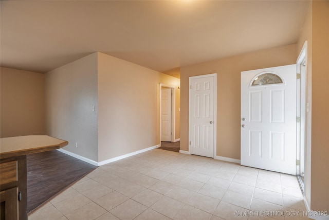 interior space featuring light tile patterned floors and baseboards