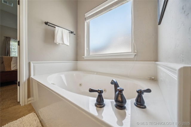 ensuite bathroom with a jetted tub, a healthy amount of sunlight, visible vents, and connected bathroom