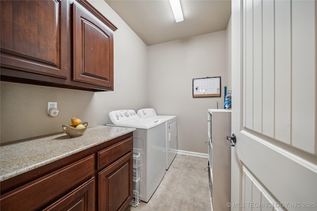 washroom with light tile patterned flooring, washing machine and dryer, and cabinet space