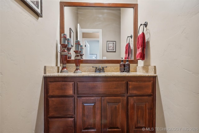 bathroom featuring vanity and a textured wall